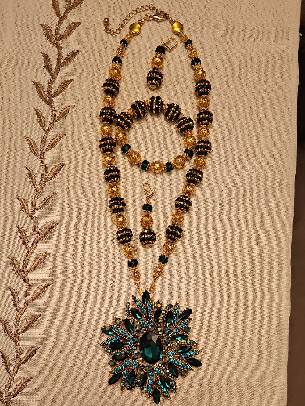 Unbranded Gold and Teal/Emerald Crystal Sunburst Pendant Necklace Set